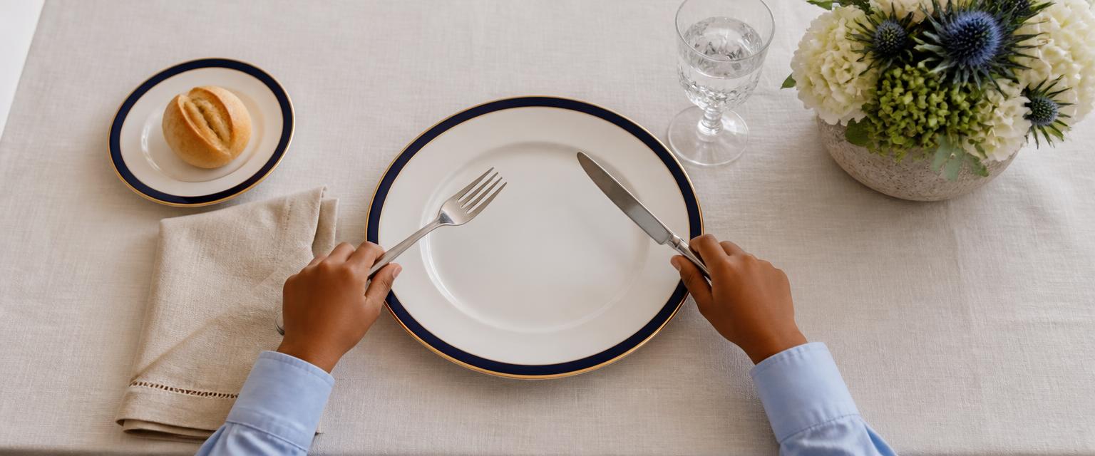 Child practicing table manners with fork and knife